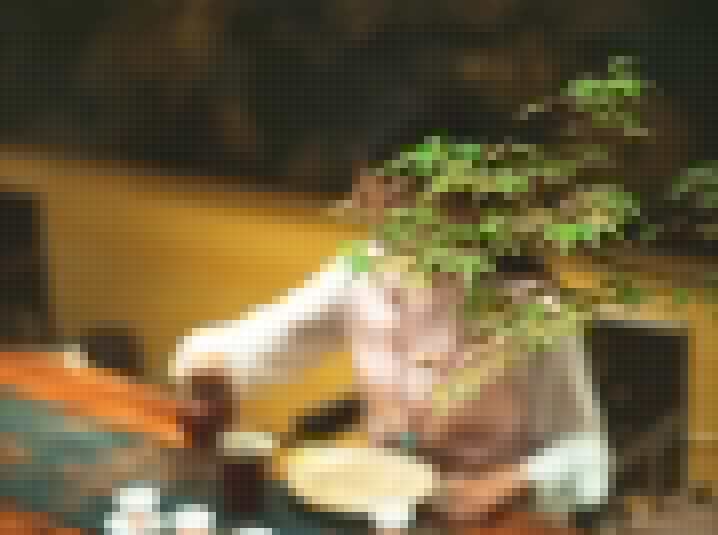 Girl holding a cup in background and tea leaves are in the front