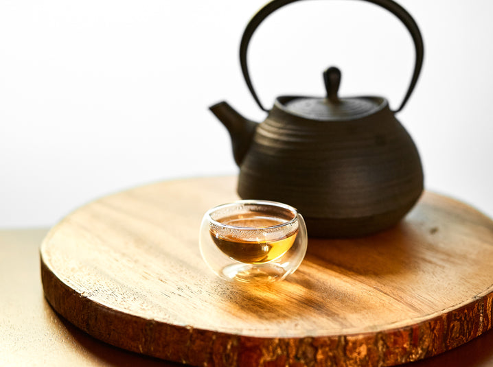 Brewed Hojicha Roasted Green Tea and teapot on a wooden tray