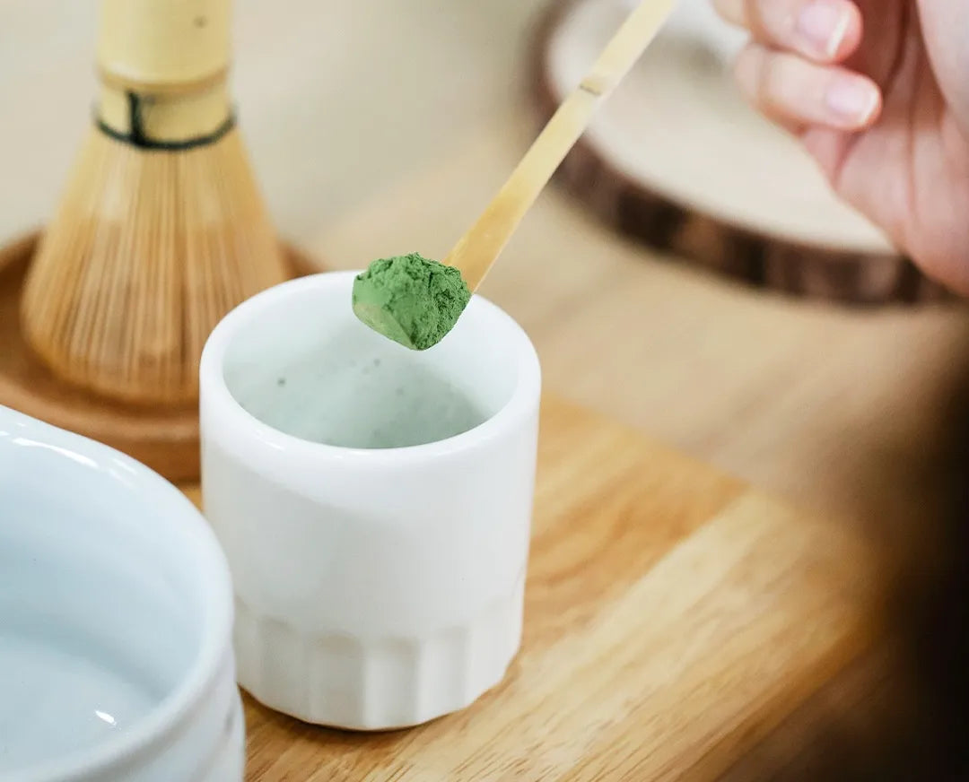 Putting Matcha powder in a cup using bamboo scoop