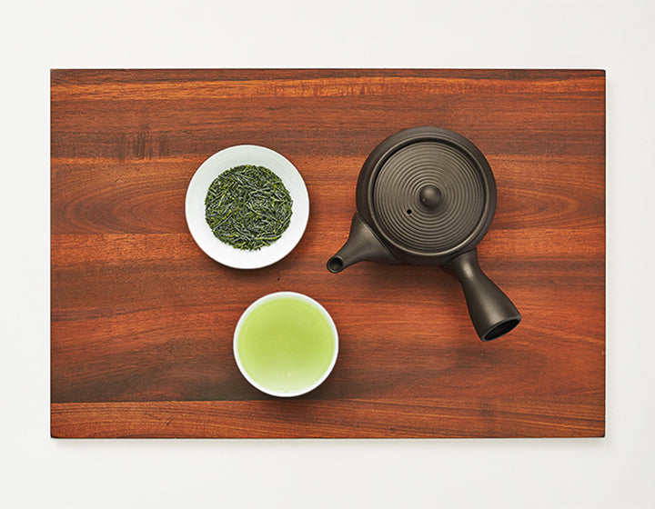 Brewed Gyokuro Shade-Grown Green Tea in a bowl with Gyokuro Shade-Grown Green Tea refill in white plate and kyusu teapot