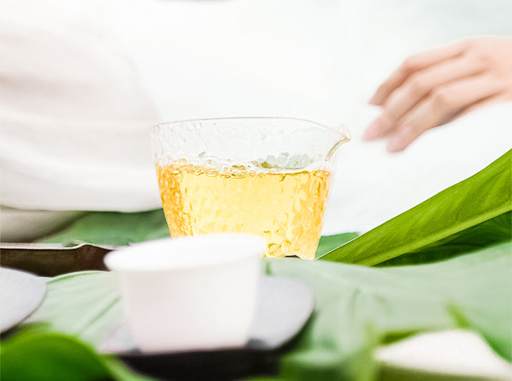 brewed Sobacha Buckwheat Tea in a glass beside white ceramic bowl