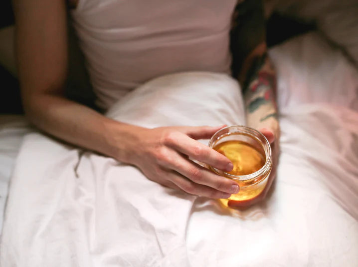 Person holding a warm cup of Japanese tea in bed for a quiet screen-free evening ritual