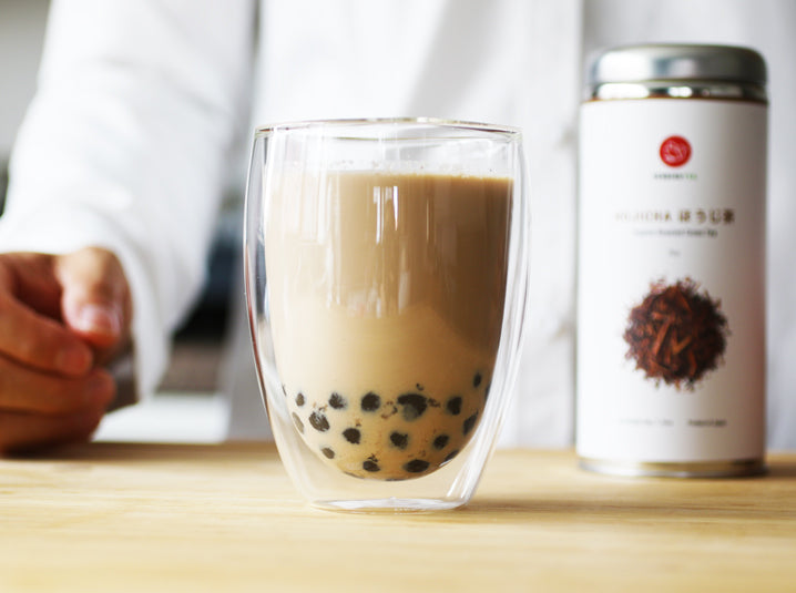 brewed hojicha bubble milk tea in a glass and hojicha tea tin