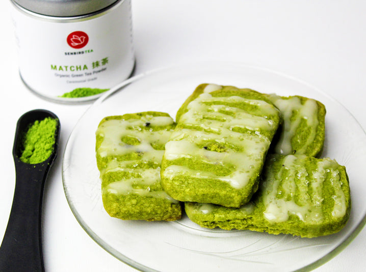 Matcha Shortbread Cookies in a plate with Match powder in a tea spoon and matcha tea tin