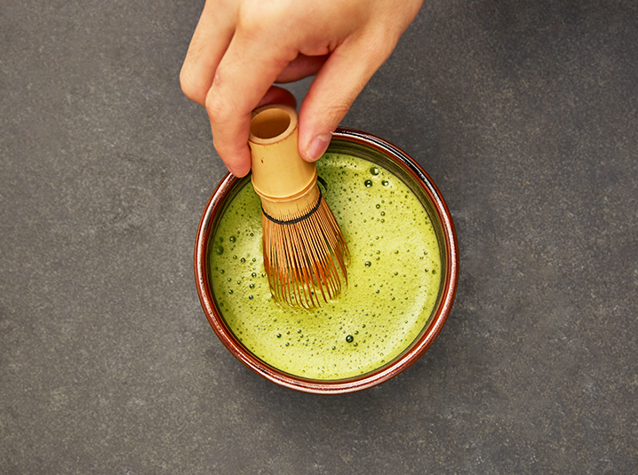 Hand whisking Matcha Green Tea in a bowl