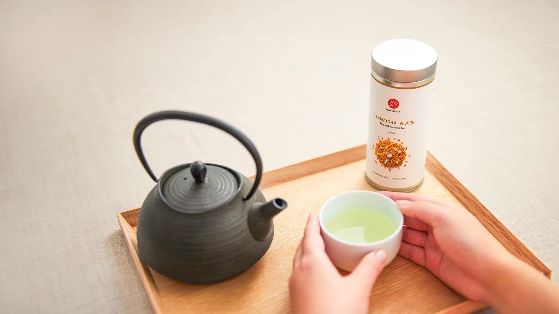 brewed genmaicha tsukimi caffeine free tea in white tea cup with tetsubin tea pot