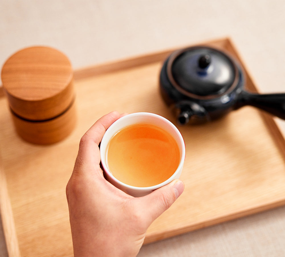 Hojicha Japanese green tea amber cup with wooden canister and kyusu teapot