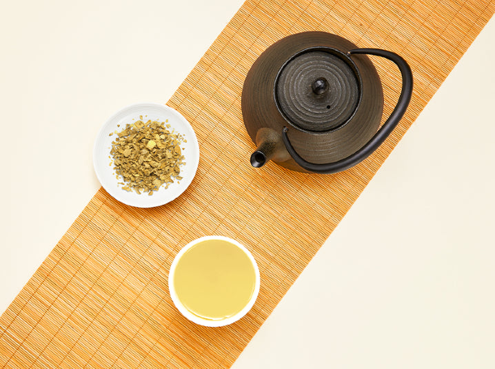 Loose ginger herbal tea and brewed Shogacha cup on bamboo mat