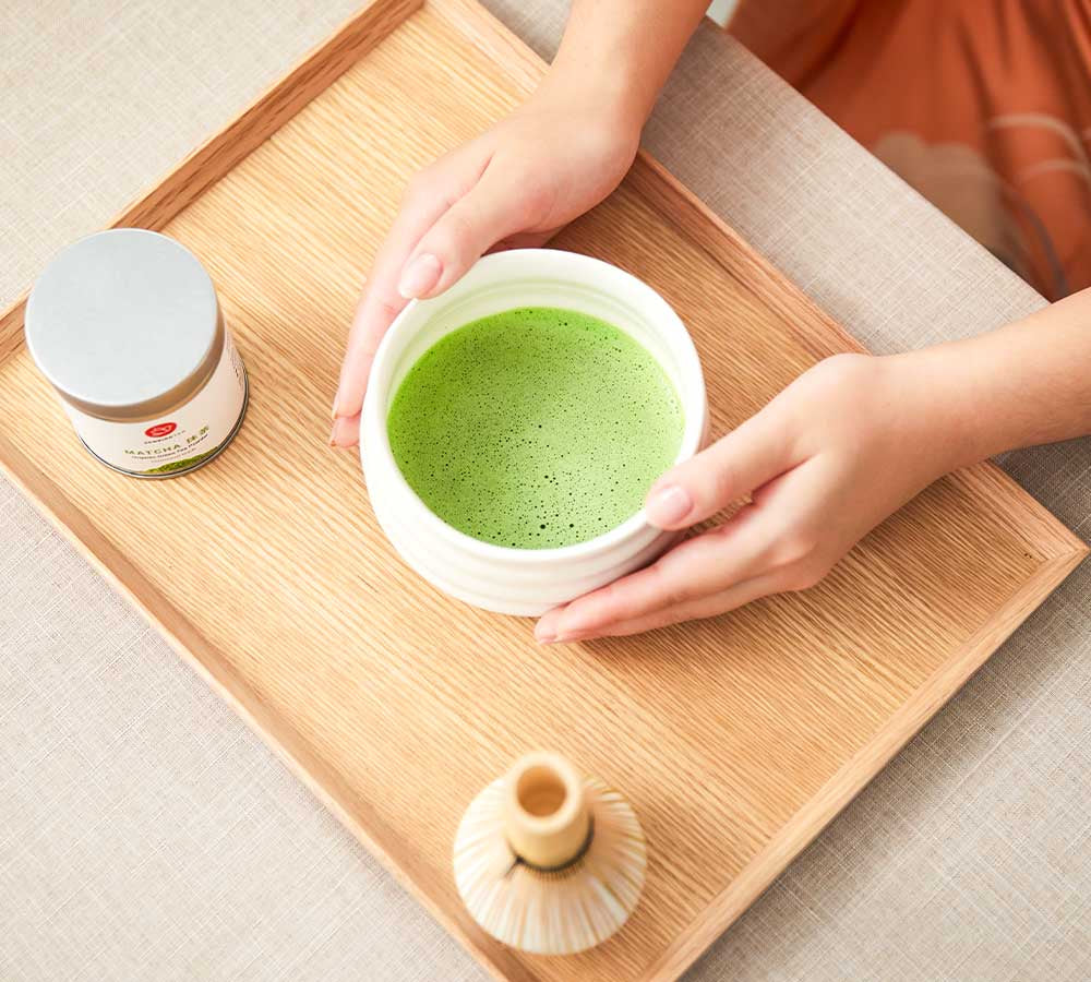 ceremonial-matcha-usucha-in-white-ceramic-matcha-bowl-bamboo-whisk-stand-matcha-otome-tea-tin-on-wooden-tray